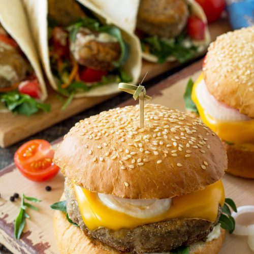Arabic cuisine. Ramadan food. Delicious fresh homemade vegetarian mung cutlets burger and tortilla with falafel on a wooden kitchen table. Street food, fast food.